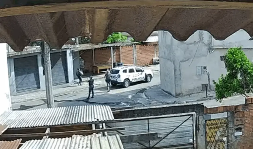 Imagem de câmera de segurança mostra viatura da PMESP estacionada enquanto policiais militares fazem fotos de um estabelecimento comercial em Piracicaba (SP).